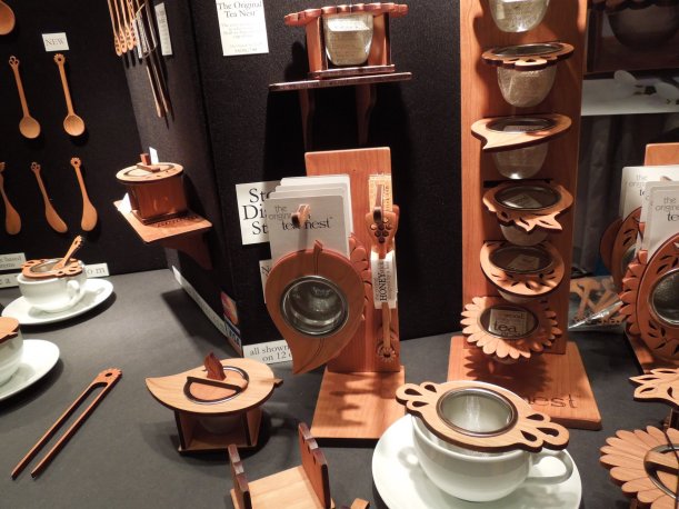 A display of tea infusers with wooden holders and a metal mesh